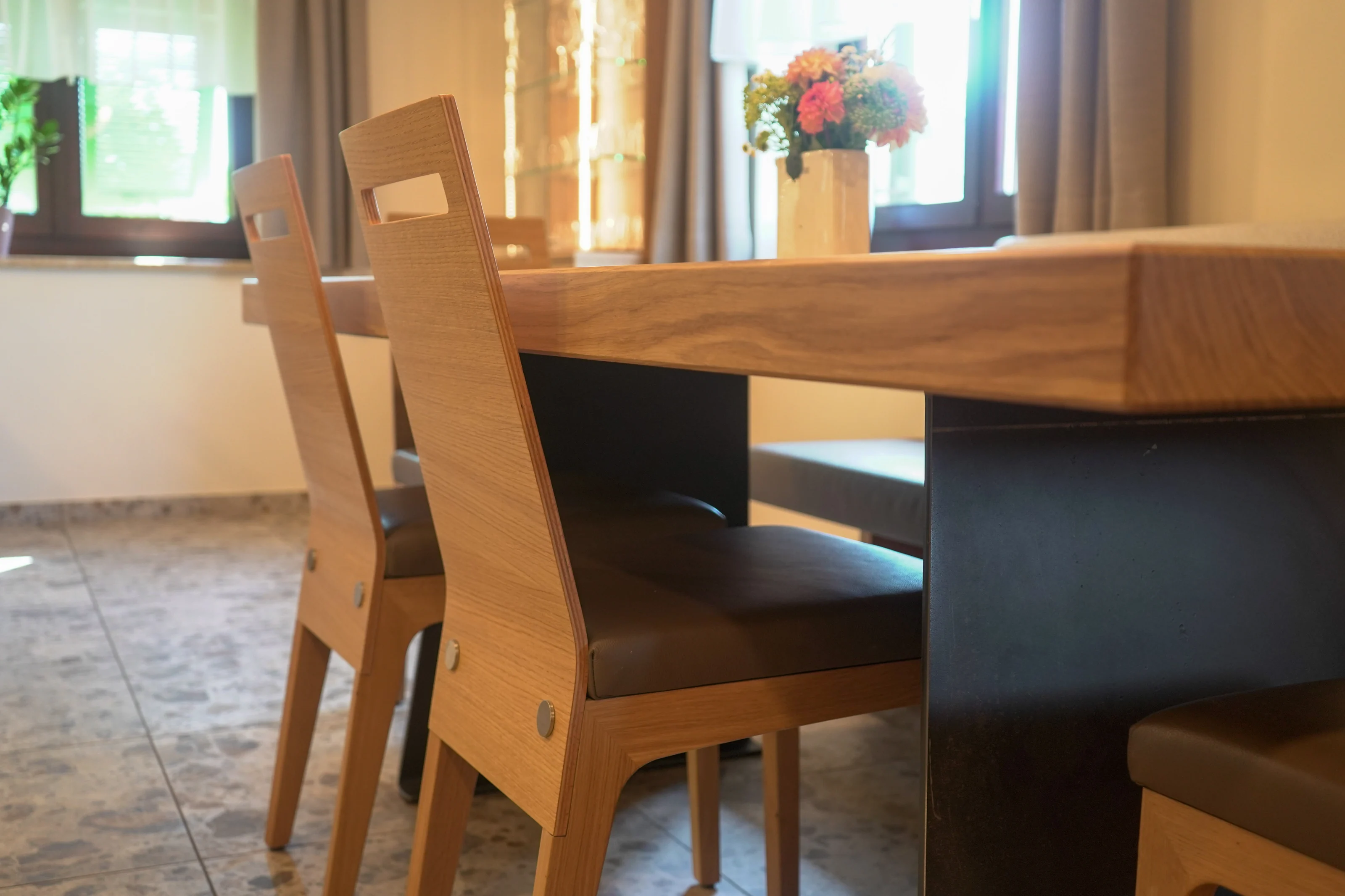 Massiver Holztisch mit passender Bestuhlung und dunklem Untergestell.