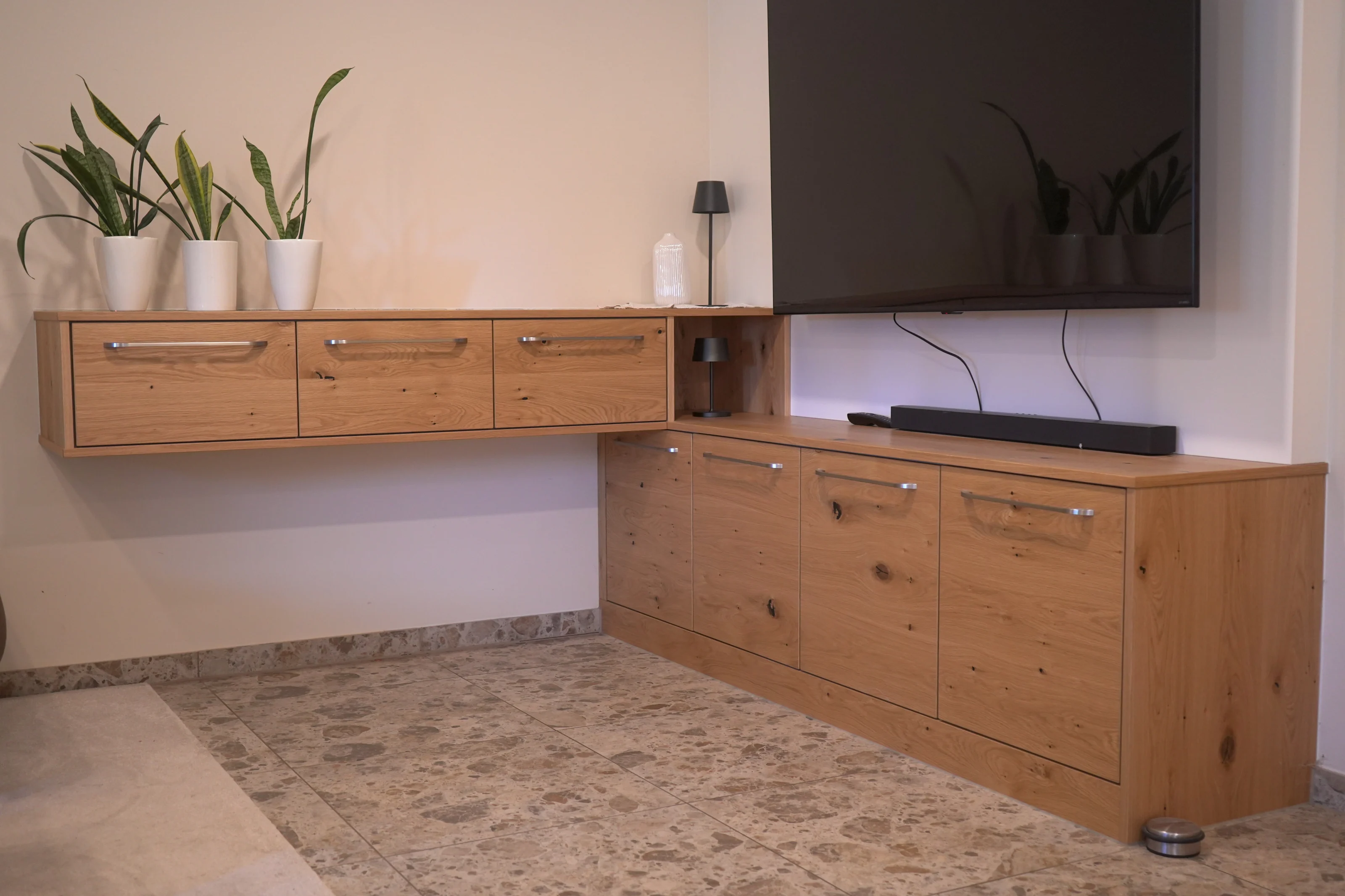 Wohnzimmer mit maßgefertigtem Holzsideboard und wandmontiertem Fernseher.